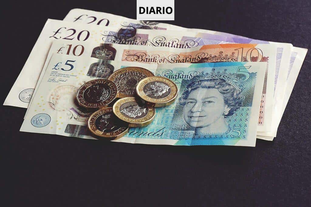 High-quality image of British pound notes and coins on a dark surface, showcasing currency detail.